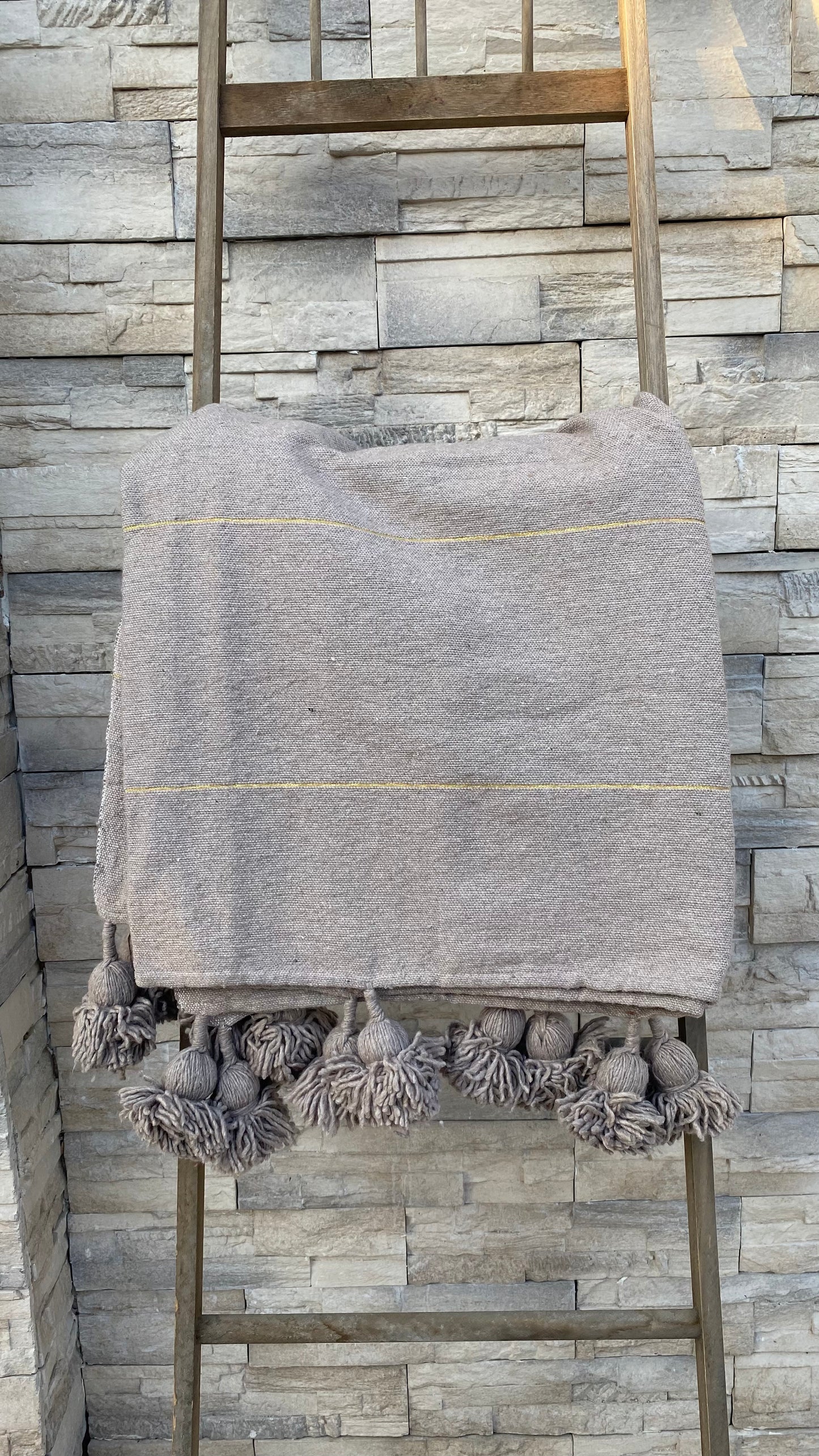 PLAID POMPONS TISSÉ TAUPE LISERÉ DORÉ